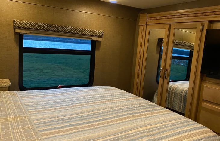 The master bedroom has a large closet, 8 drawers, storage behind TV, Blue-Ray/DVD player, and cabinets over bed