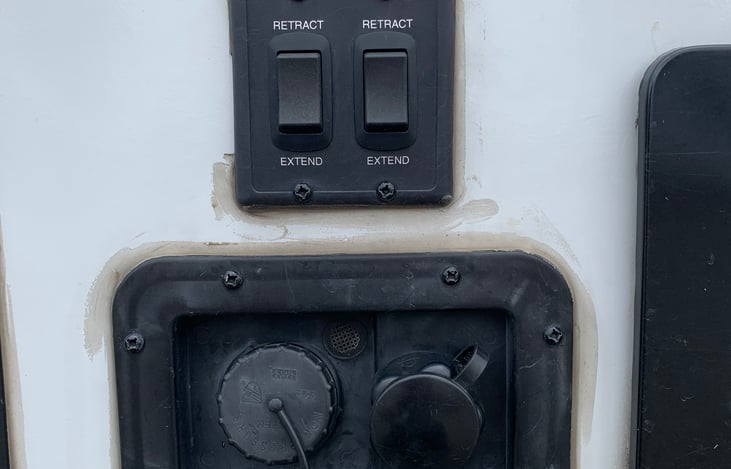 Electric stabilizer switches and the ports to the fresh water tank fill (left) and water hook up (right)