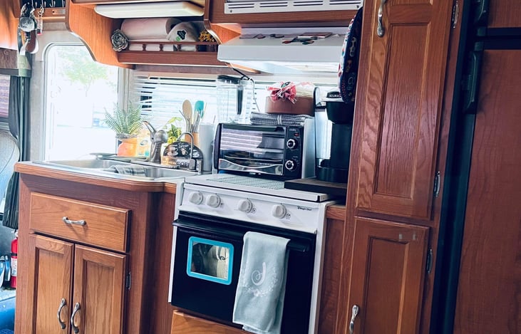 All well maintained kitchen appliances with plenty of dishes, utensils and cookware.