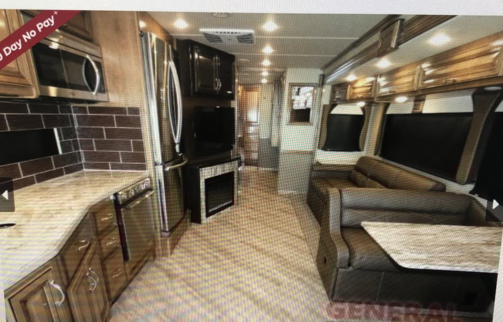 Kitchen, dinette, sofa, fireplace and entertainment - 
 dealership photo of this motorhome