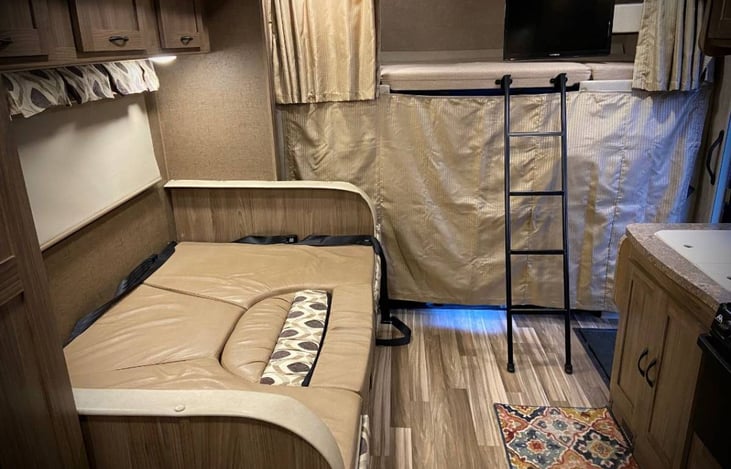 Dinette converted to a bed with bunk space above cab provide sleeping space for 4 people. Cover provides additional privacy.