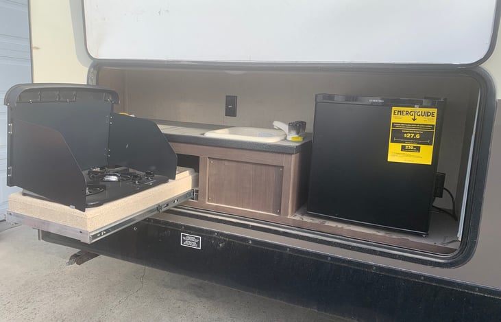Outdoor kitchen with sink and propane grill and mini fridge.  The requires full hookups because it runs off of full electricity.