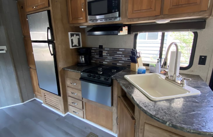 Kitchen is equipped with stove, microwave, refrigerator, coffee pot, and all necessary pots and pans, plates, bowls, cups, and utensils.