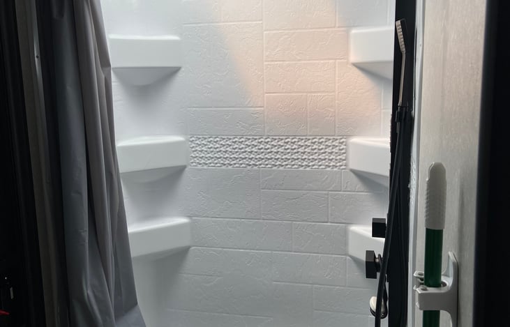 View of full shower/tub with waterfall style shower head