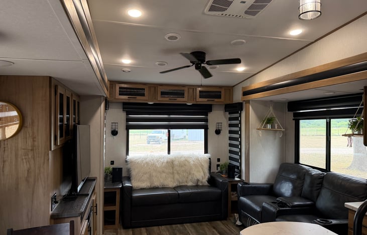 Designed for entertainment, featuring panoramic windows that flood the space with natural light. Deluxe theater seating sits directly across from a cozy fireplace and large entertainment center.