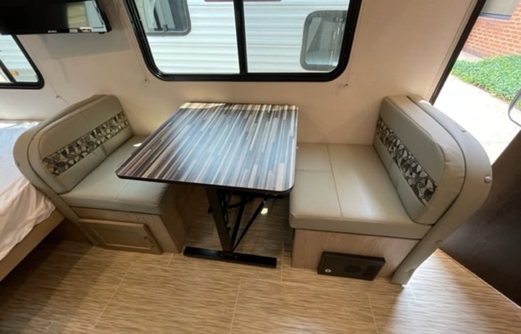 The dinette table not only serves as a convenient space for dining and socializing but also transforms into a cozy sleeping area for one.