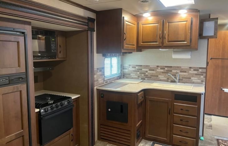 Kitchen featured 3 burner stove, oven, microwave and large fridge and freezer