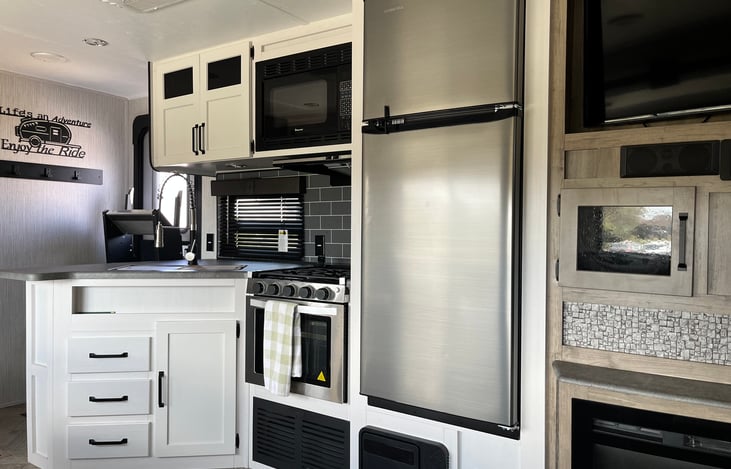 Kitchen with microwave, stove and large refrigerator.