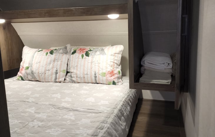 Comfortable bed with foam topper. Extra blankets, sheets, and a small fan.