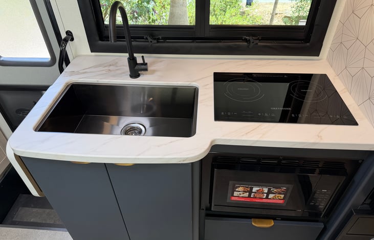 Kitchen has a table that pops out on the side and a cover for the sink if you need more counter space.
