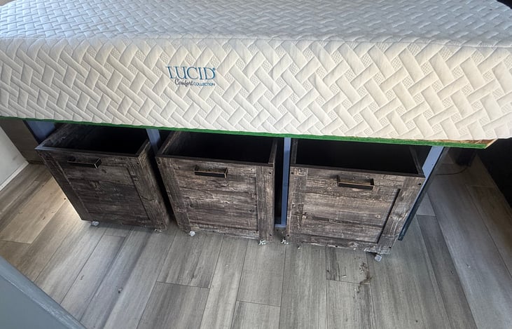 No lifting the bed to reach the storage. The end panel has been removed and 3 rolling crate drawers have been installed underneath -- much easier to access.
