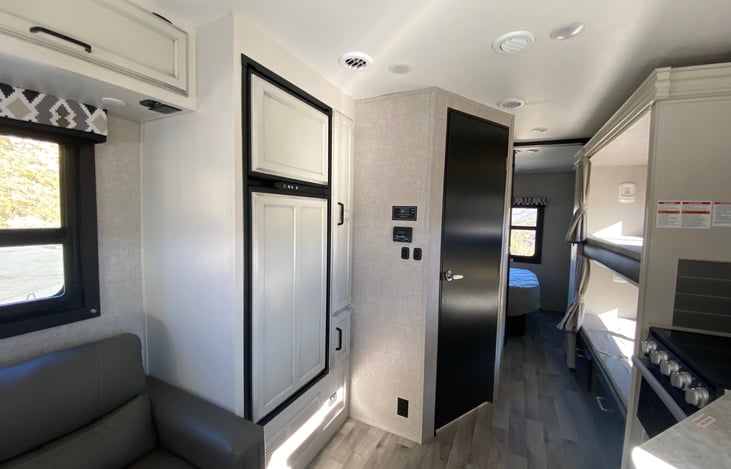 Fridge is to the left from entrance door to the bathroom