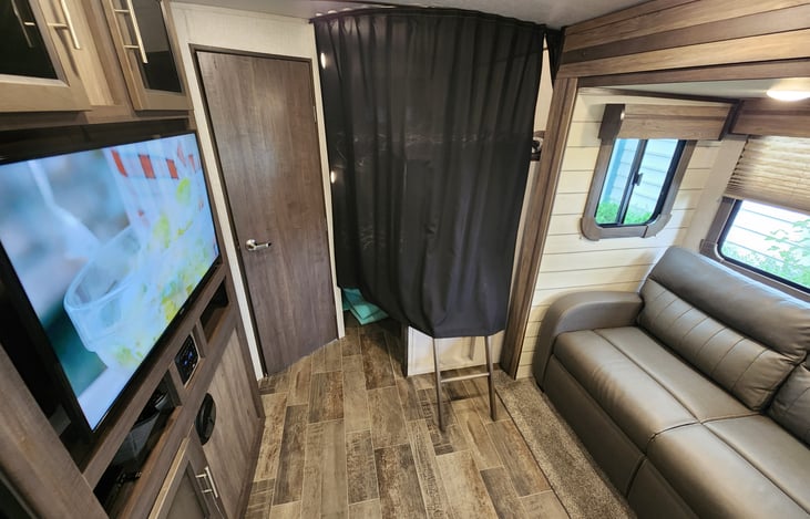 Privacy curtain and ladder for bunks right off of main living room area.