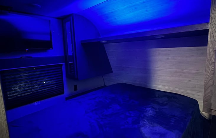 Queen size bed with tv and also blue relaxing led light