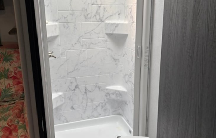 Closet shower to keep clean on the road. Accordion shower door. Camp toilet and plenty of towel hooks.