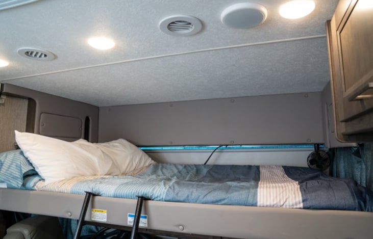 Full sized over cab bunk raises to drive and lowers to sleep all with the push of a button.