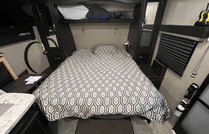 Queen-size murphy bed with reading/night lights and storage above.