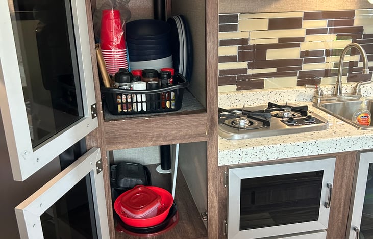 Fridge/Freezer/Storage - Stocked with cups, plates, bowls, spices, storage containers/bags, strainer, cutting board, additional paper towels, additional RV friendly toilet paper, first aid kit.