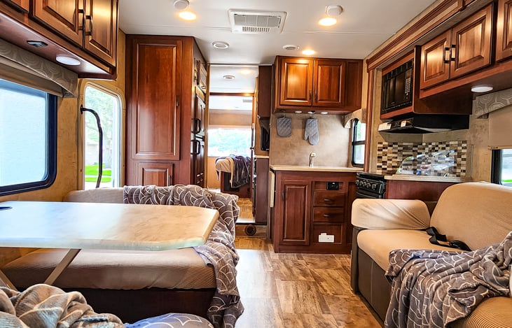 Fred the Forester's living room and kitchen feature a cozy, open layout. The living room has a convertible sofa or dinette, while the kitchen is compact with modern appliances and ample storage.