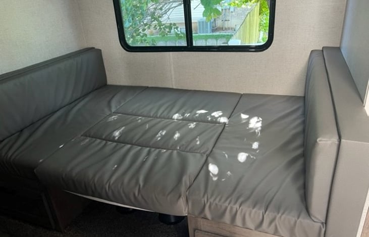 U-Shaped dinette area converted into a full size bed. (White spots in picture are from sunlight).
