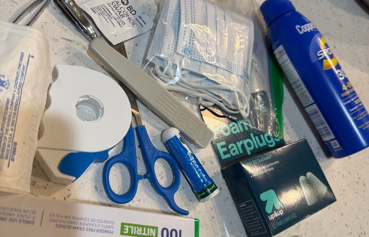 First aid kit. I tried to think of everything you might need in an emergency. Gloves, bandaids, antibiotic, scissors, mouth thermometer and earplugs to name a few.