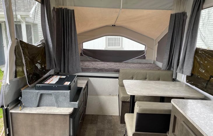 The stove, dining table and one sleep area. Both sleep areas feature memory foam mattresses that can be heated and a curtain for privacy.