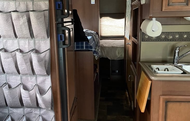 This is the hallway before the slide-out is extended. There is space enough to access the bedroom and bathroom during a quick stop while on your way to your destination! Also, shoe storage!