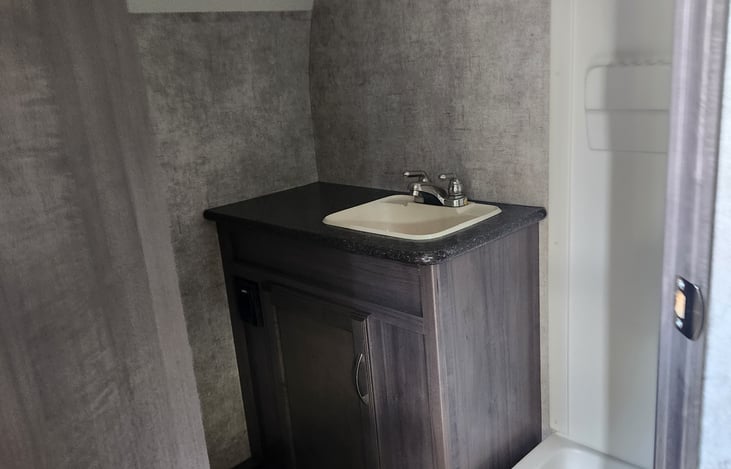 No campground lines here! Enjoy your own private bathroom with a full shower and toilet -small space, big convenience.