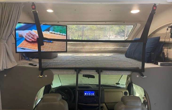 Another view of over-cab bed with safety net in place that is used while driving to keep items in place