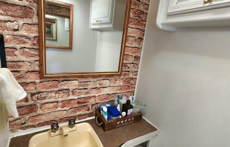 This is the toilet room which has a door with a full mirror on the outside. We include deodorants, toothpaste, first-aid, sanitary products, rags, towels, rv toilet paper, shavers, etc. Just in case.