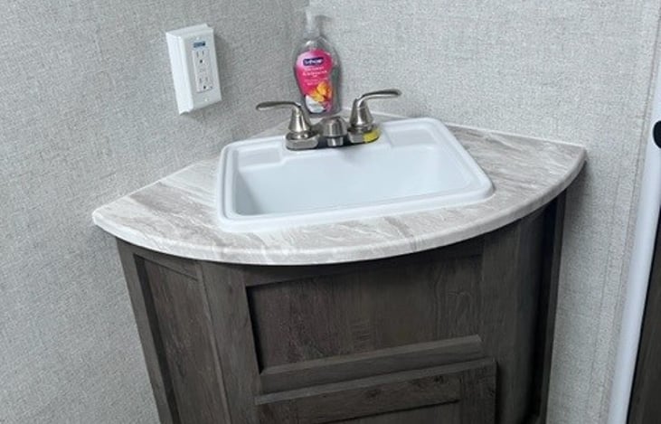 Bathroom sink with lower cabinet space. Mirrored medicine cabinet with four shelves  (not pictured).