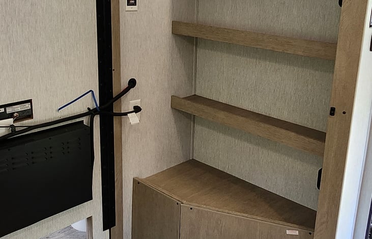 Hidden storage closet behind the TV/fireplace.  Great spot to store the foldable cot.