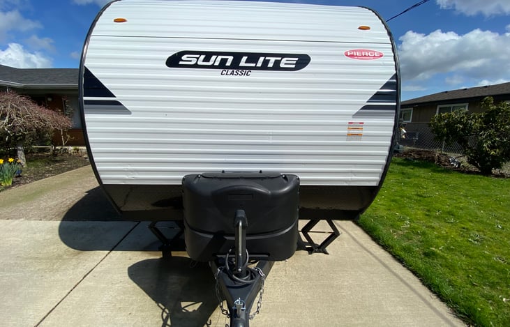 Front view: 2x propane tank (covered), RV chain and tow package