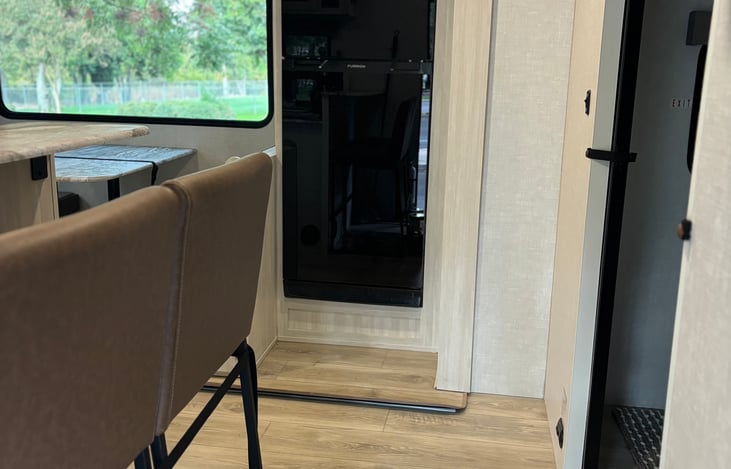 Entry area with bar top and stools. Pop out if for fridge and table.