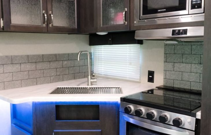 Indoor kitchen area. Equipped with dishes, silverware, knives, kitchen utensils, limited: pots and pans, serving dishes, cups and bowls