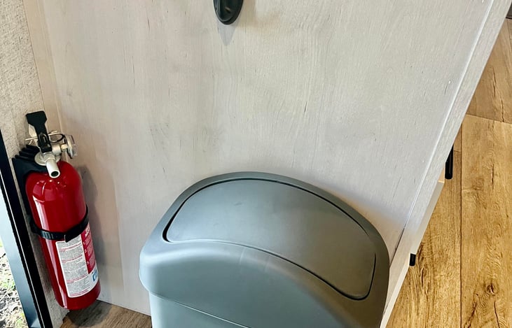 TRASH BIN WITH BAGS INCLUDED. ALSO, FOR ADDED SECURITY, THE RV IS EQUIPPED WITH FIRE EXTINGUISHER, FIRE ALARM AND CARBON MONOXIDE DETECTOR.