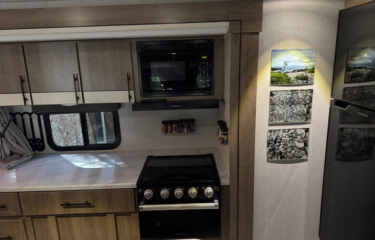 Well-equipped kitchen with stove and oven, cookware and glassware included. The center island provides extra prep space and a sink, and a built-in microwave makes it easy to heat meals or snacks while