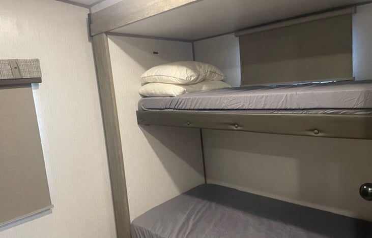 Bunkroom with 3 single beds and TV.