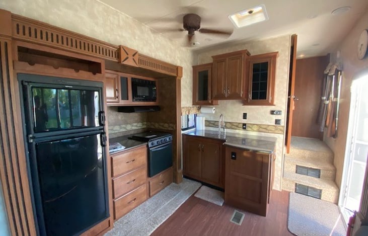 Kitchen and living space. Large fridge and freezer, oven and 4 burners all cooking supplies included. Sink with cleaning supplies. Salt and pepper and napkins above sink.
