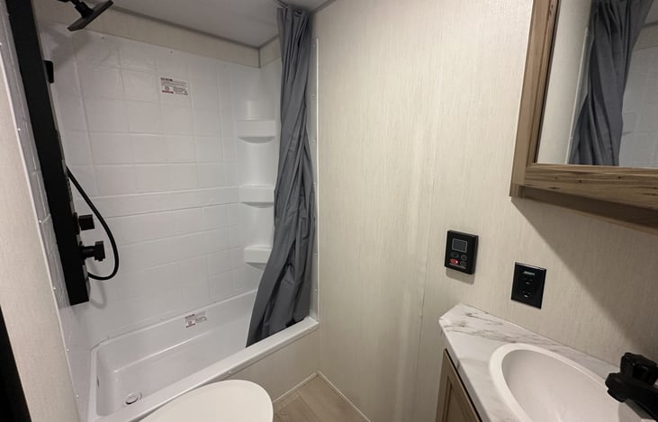 Kitchen cabinet, sink, stove, and refrigerator area for renter meal prep.