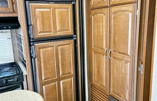 Large RV with outdoor kitchen, fireplace, and TVs