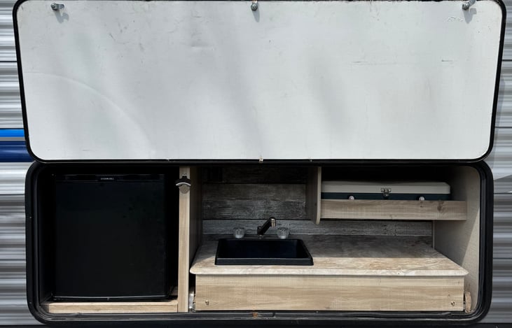 Outdoor fridge, sink and griddle is a great spot to food prep around the fire