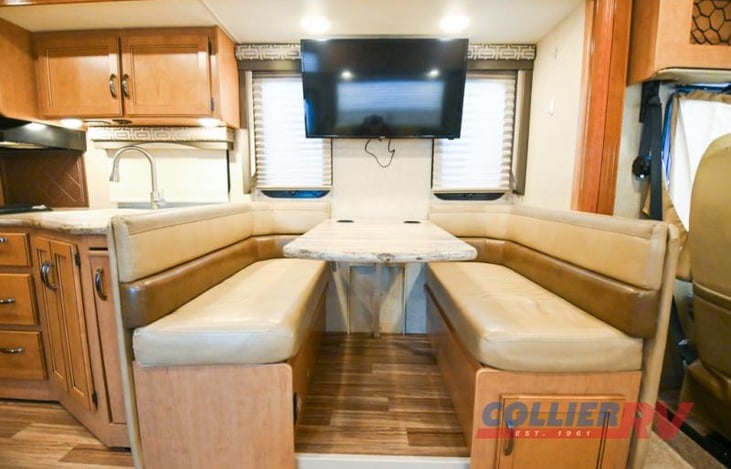 68" Dining area converts into sleeping space, with storage below the benches.  40" TV above