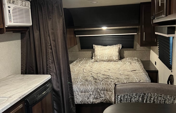 View of the bedroom/dining area from the entrance of the trailer. A curtain can be closed for privacy in the sleeping area.