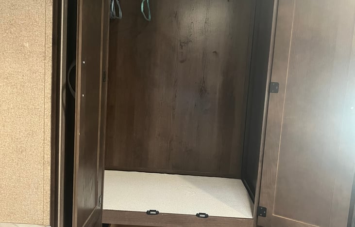 Large closet and drawer next to queen bed.