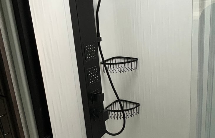 Shower head has three different spraying options as well as a wooden fold down bench seat and sliding glass doors