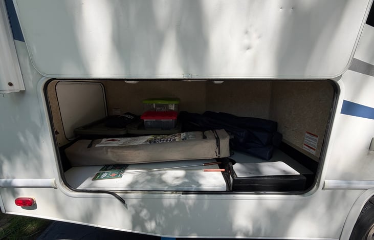 Rear outside storage with chairs table and supplies.