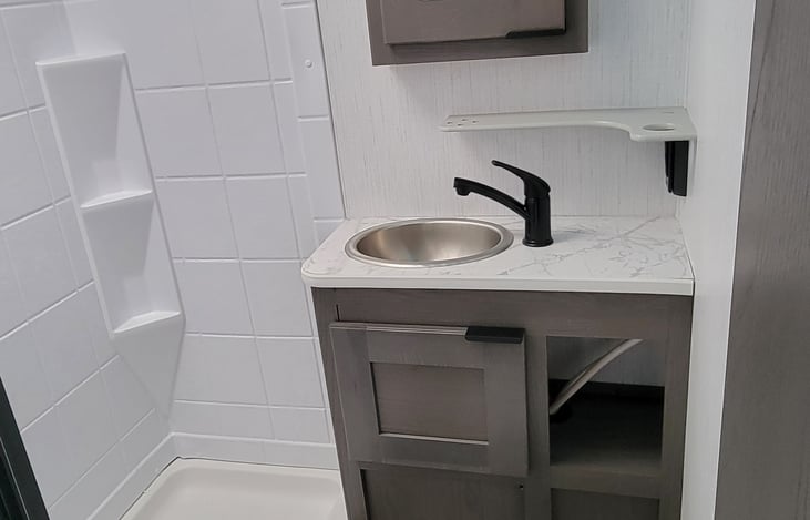 The bathroom with a shower, toilet, sink, and moon roof!