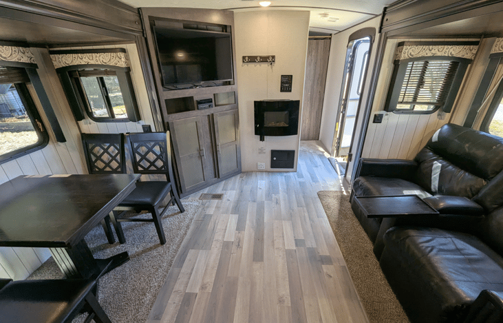 Very spacious living area offers a cozy retreat with theater-style recliners, a premium entertainment system, fireplace, TV, dinette and well-equipped kitchen.