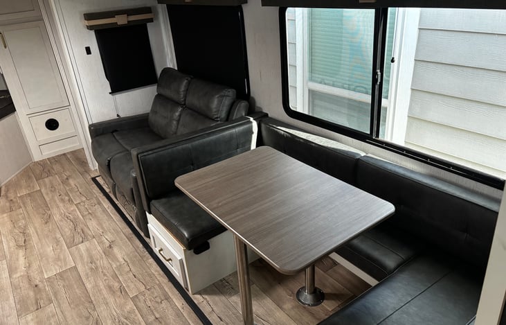 U shaped table that can become a bed if necessary. Theater reclining seating next to table